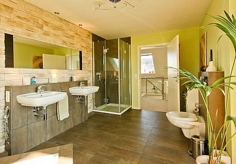 ECO System HAUS – Badezimmer in grün und braun mit Waschbecken, Dusche und WC